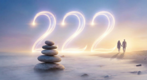 Glowing Angel Number 222 symbol illustrating balance and harmony above a stone cairn and a couple walking on a beach at sunset.
