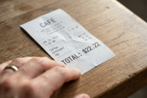 A realistic close-up of a restaurant bill showing a total of $22.22, illustrating a common daily encounter with Angel Number 2222.