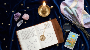 Horizontal flat lay featuring an open leather journal with constellations, healing crystals, a gold pendant, and The Star tarot card on dark blue velvet, perfectly capturing zodiac aesthetics and mystical style.
