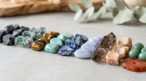 A winding row of powerful protection crystals, including shungite, fluorite, and lapis lazuli, arranged on a smooth concrete surface.